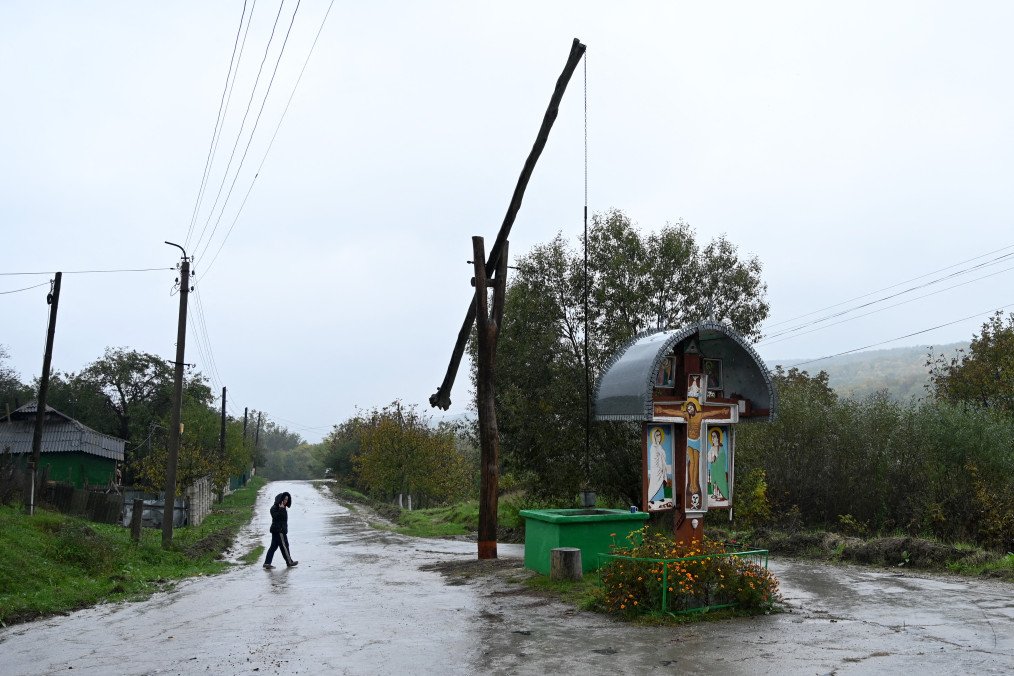 A woman crosses a road in the village of Oricova, some 60 km northwest of Chisinau. (Source: Getty Images)