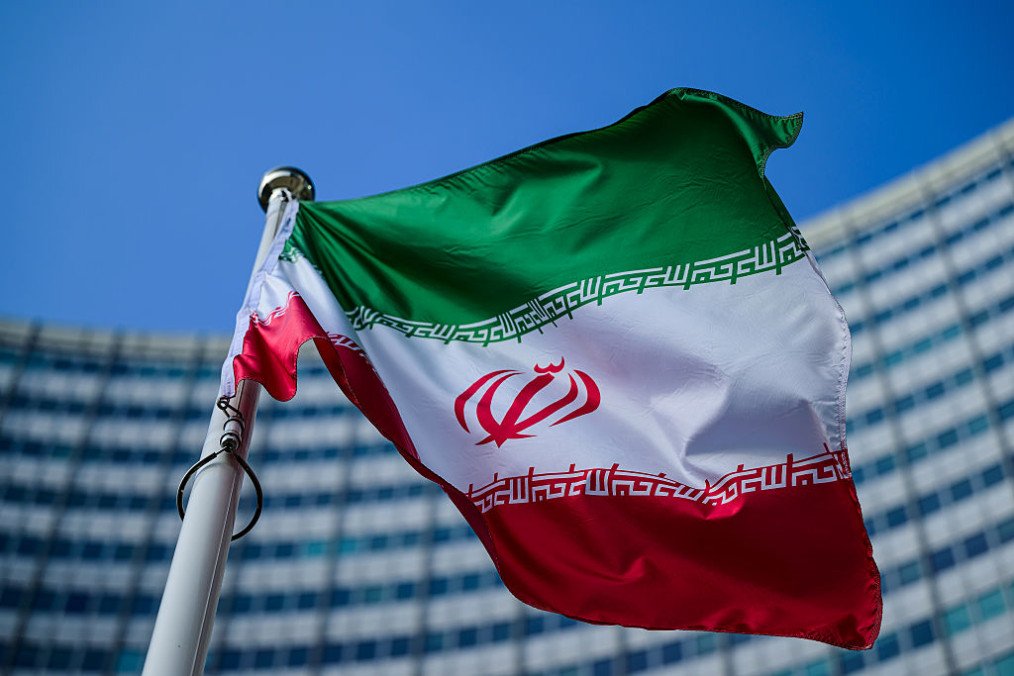 The flag of Iran is seen outside the International Atomic Energy Agency (IAEA) headquarters during a meeting of the IAEA Board of Governors on March 2, 2026 in Vienna, Austria. (Source: Getty Images)