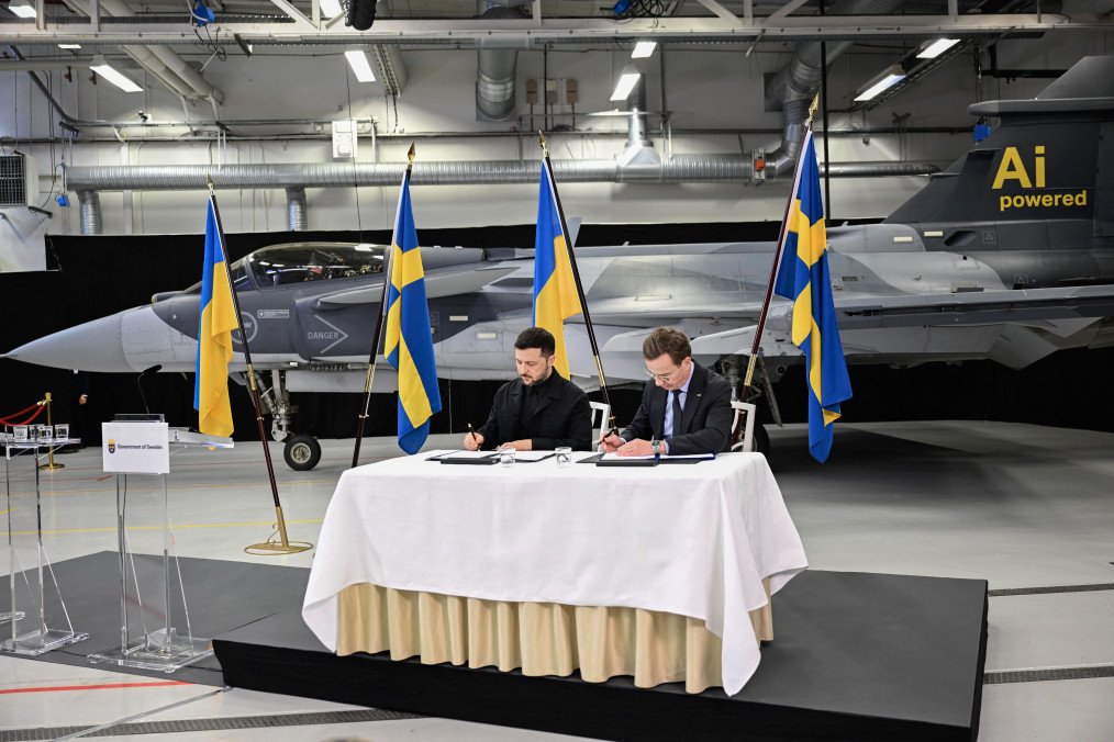 El primer ministro sueco, Ulf Kristersson, y el presidente ucraniano, Volodymyr Zelenskyy, firman una carta de intención frente a un avión de combate Gripen en Linköping, Suecia, el 22 de octubre de 2025. (Fuente: Getty Images)