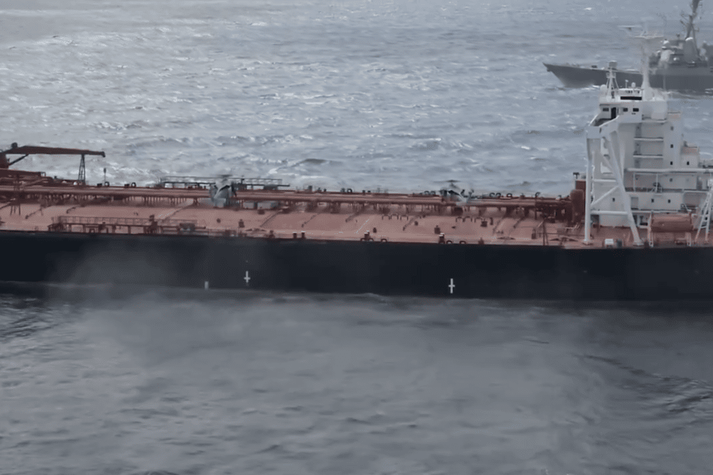 Video still released by the US Department of War shows the oil tanker Veronica III underway at sea, with a US naval vessel visible nearby during the interception operation. (Source: US Department of War)