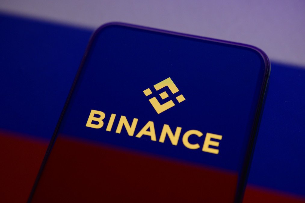 The Binance logo displays on a smartphone screen placed on a reflective surface onto which a Russian flag is projected. (Source: Getty Images) The Binance logo displays on a smartphone screen placed on a reflective surface onto which a Russian flag is projected.
