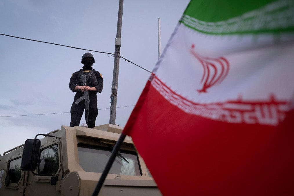 An armed Iranian police officer stands guard on an armored vehicle, monitoring the area during a state-run religious rally in downtown Tehran, Iran, on April 29. (Source: Getty Images)