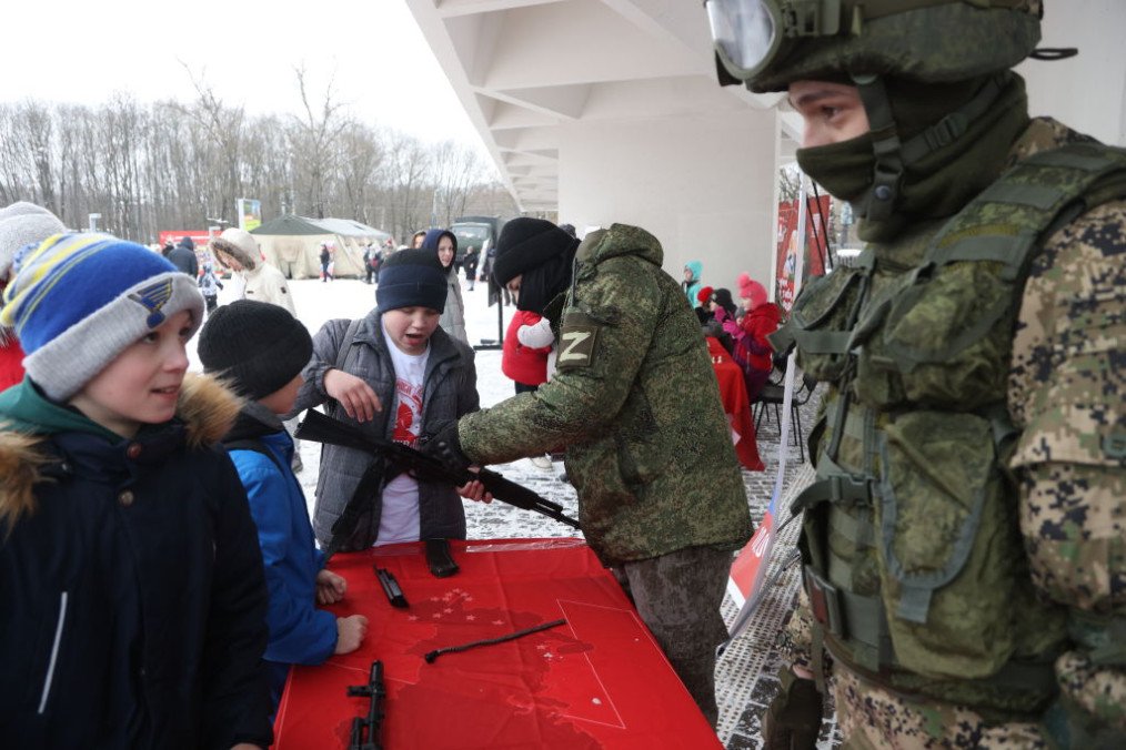 An officer of Russian Army officer demonstrates a Kalashnikov assault rifle to a boy during a pro-military event in the suburbs of Moscow, Russia. (Source: Getty Images)