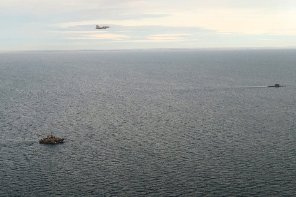 A Swedish fighter jet and naval vessel monitor a Russian submarine in the Kattegat Strait between Denmark and Sweden. (Source: Swedish Navy)