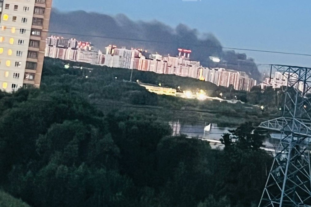 Smoke rises in the distance behind residential high-rises following a reported drone strike on Moscow region overnight August 18, 2026. (Source: Exilenova+)
