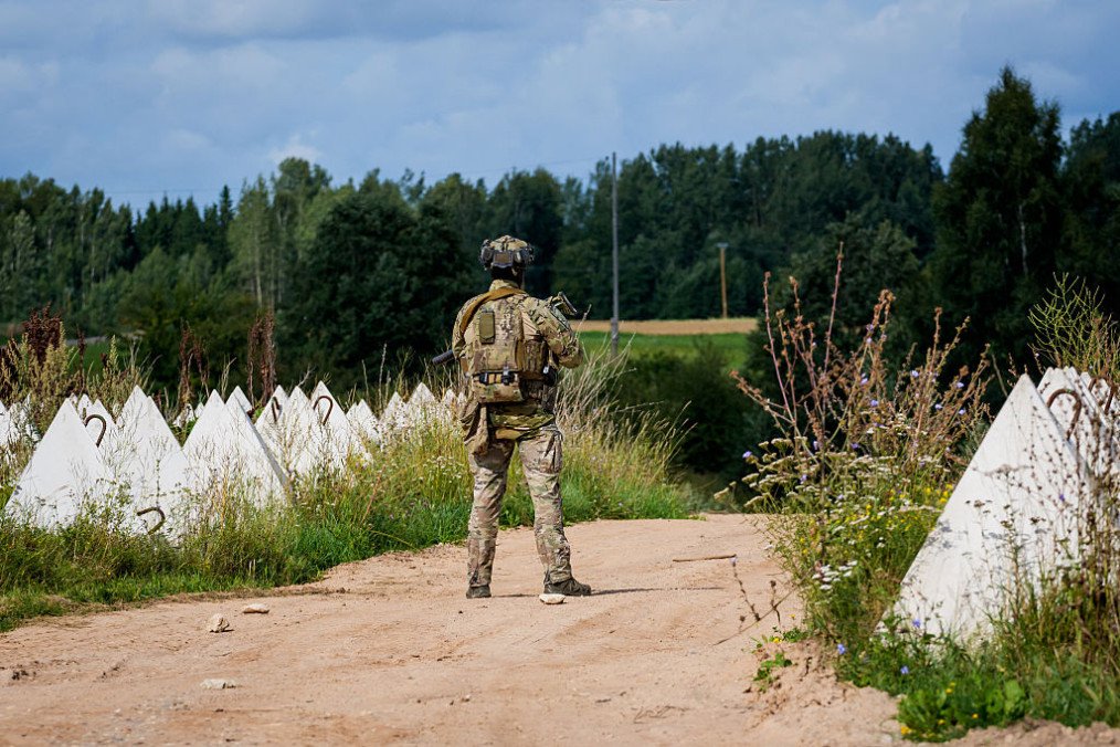 A State Border Guard patrols near dragon’s teeth anti-tank obstacles of reinforced concrete used to impede the movement of military vehicles on the border between Latvia and Belarus, on August 17, 2026 in Piedruja, Latvia. (Source: Getty Images)