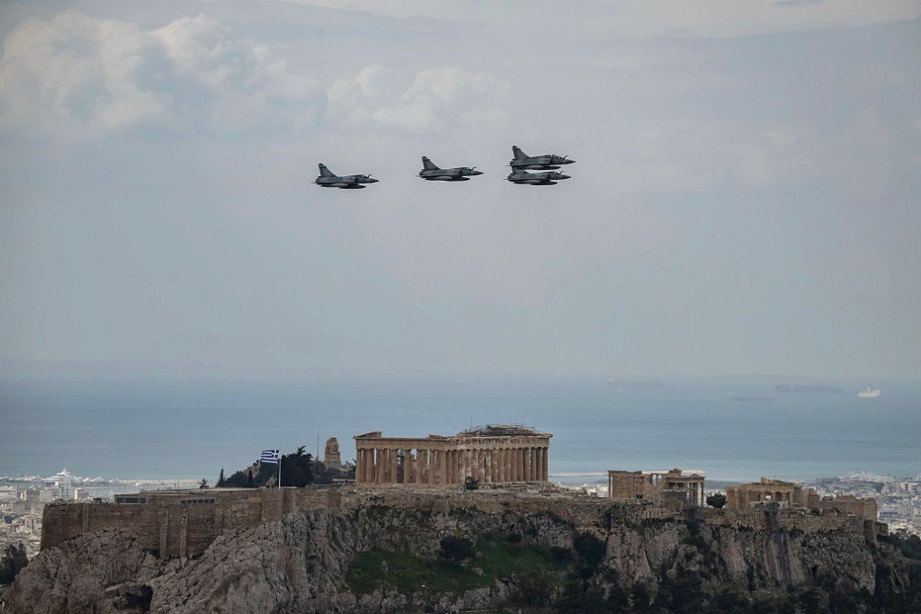 Hellenic Air Force fighter aircrafts Dassault Mirage 2000 fly over the ancient temple of Parthenon atop the Acropolis hill during a military parade marking Greece’s Independence Day in Athens, on March 25, 2026. (Source: Getty Images)