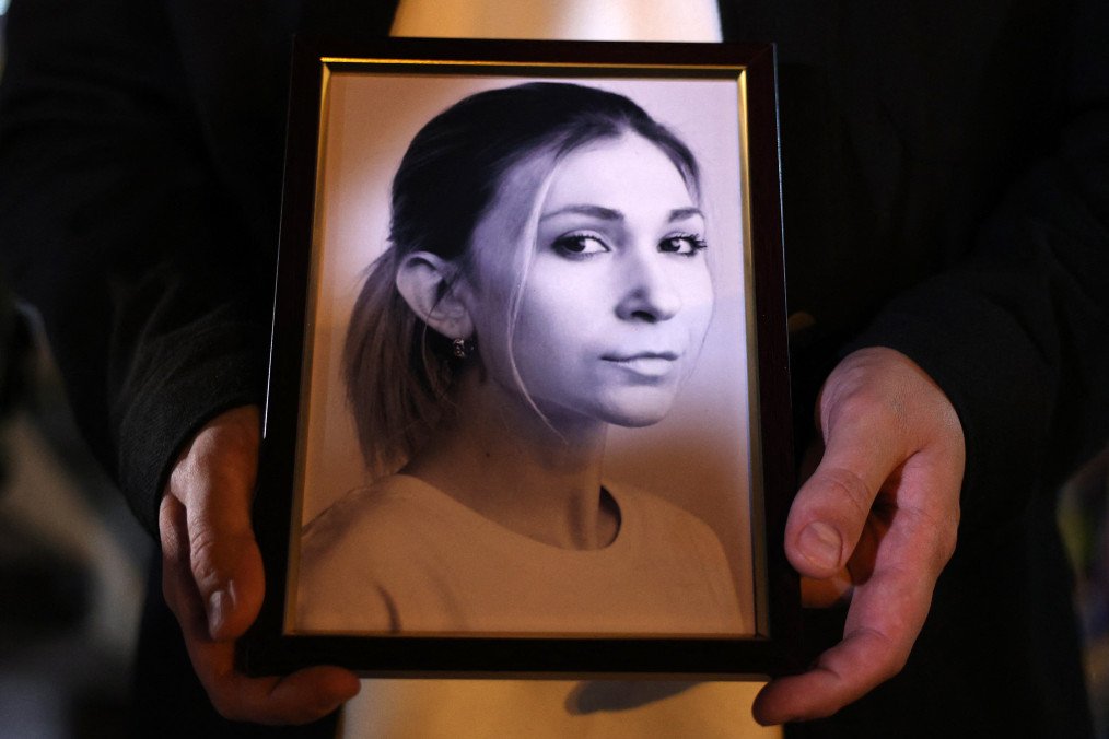 A colleague of Ukrainian journalist Victoria Roshchyna holds a photograph of her during an event in honor of Victoria's memory at a makeshift memorial for fallen Ukrainian soldiers, at Independence Square in Kyiv. (Source: Getty Images)