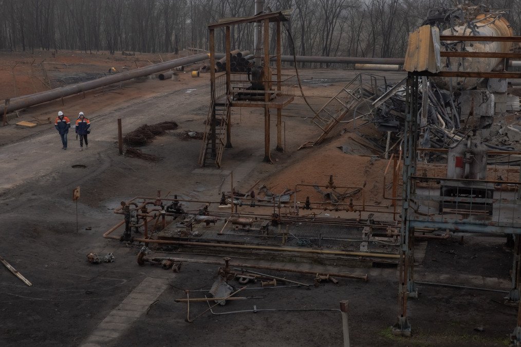 Employees walk past damaged parts of the Naftogaz gas facility, following Russian missile and drone attacks, in Ukraine, on December 2, 2025. (Source: Getty Images)