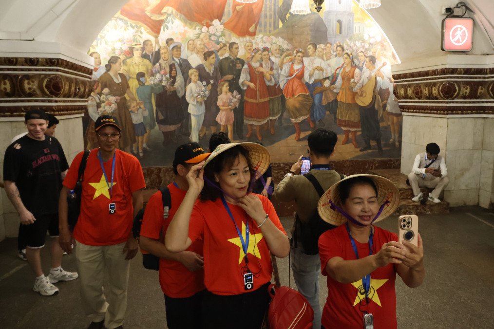 Putin Opens Borders to Vietnamese Travelers for 30 Days as Moscow Expands Ties Vietnamese tourists take photos in front of a Soviet-era mural depicting installed at the Kievskaya metro station, on May 15, 2026 in Moscow, Russia. (Source: Getty Images)