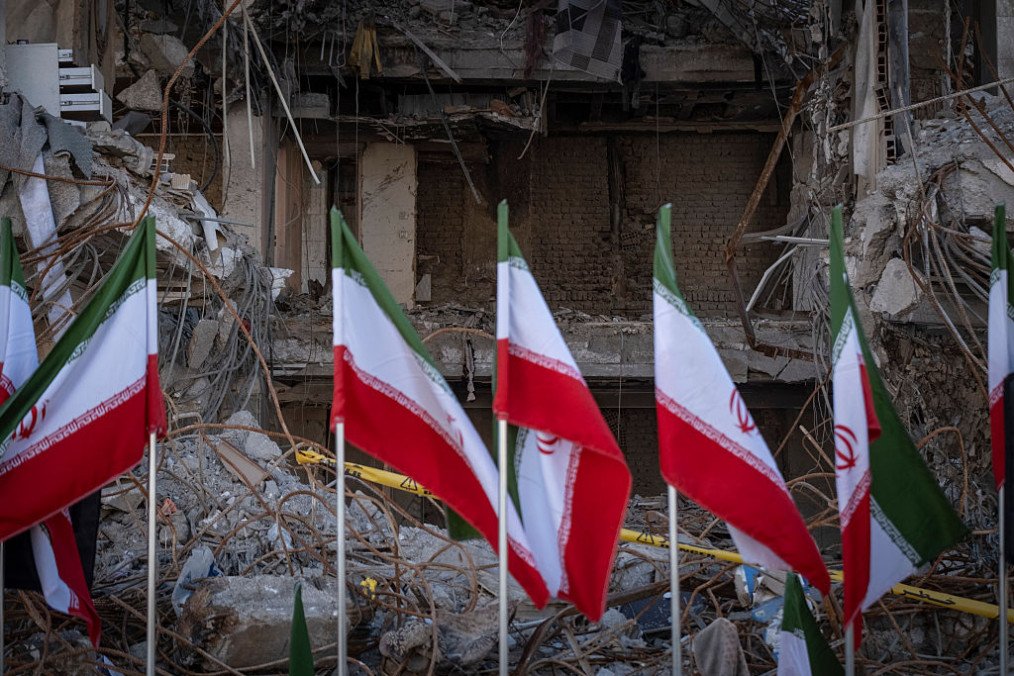 Iranian national flags are placed in front of the ruins of a building in Tehran, Iran. (Source: Getty Images)