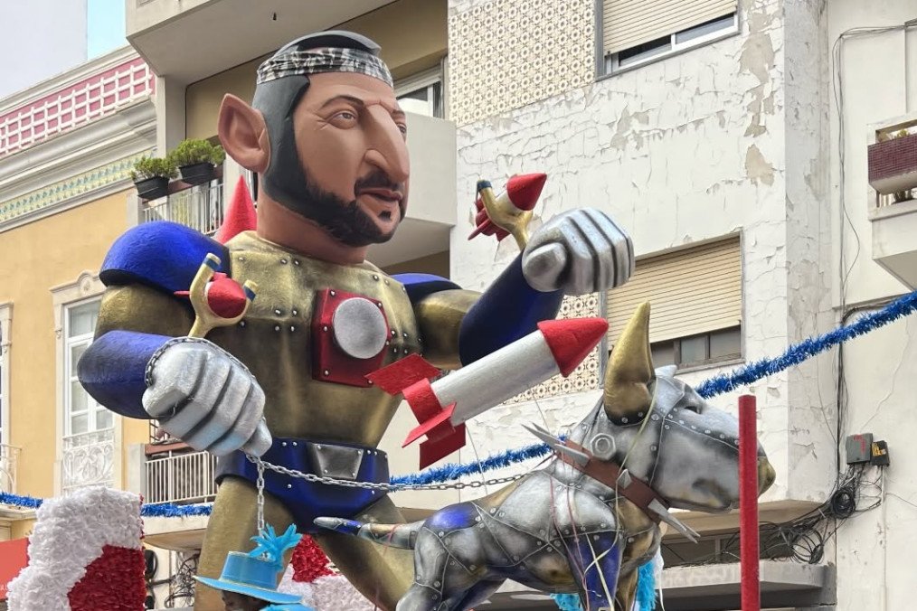 A carnival float featuring a caricature of Volodymyr Zelenskyy in knightly armor with rockets, accompanied by a robotic dog, parading at the Entrudo Carnival in Portugal. (Source: Alona Kuznetsova/Threads)