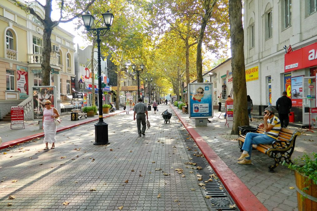 Pedestrians walk along a tree-lined street in Kerch, Crimea. (Source: Wikimedia)