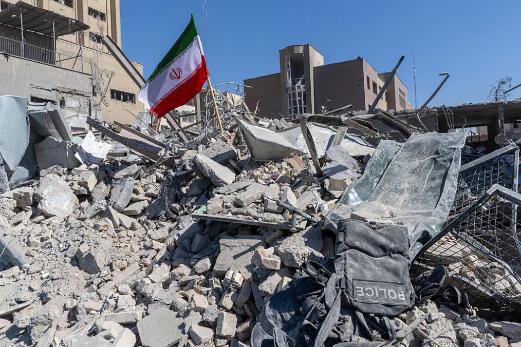 An Iranian flag is planted in the rubble of a police station, damaged in airstrikes on March 3, 2026 in Tehran, Iran. (Source: Getty Images)