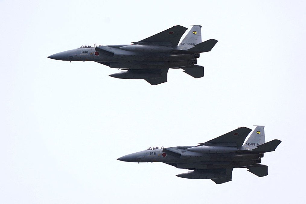 A pair of Japan Air Self-Defense Force F-15 fighter jets perform a flypast during a review parade as part of the National Defense Academy Entrance Ceremony in Yokosuka, Kanagawa Prefecture on April 5, 2026. (Source: Getty Images)