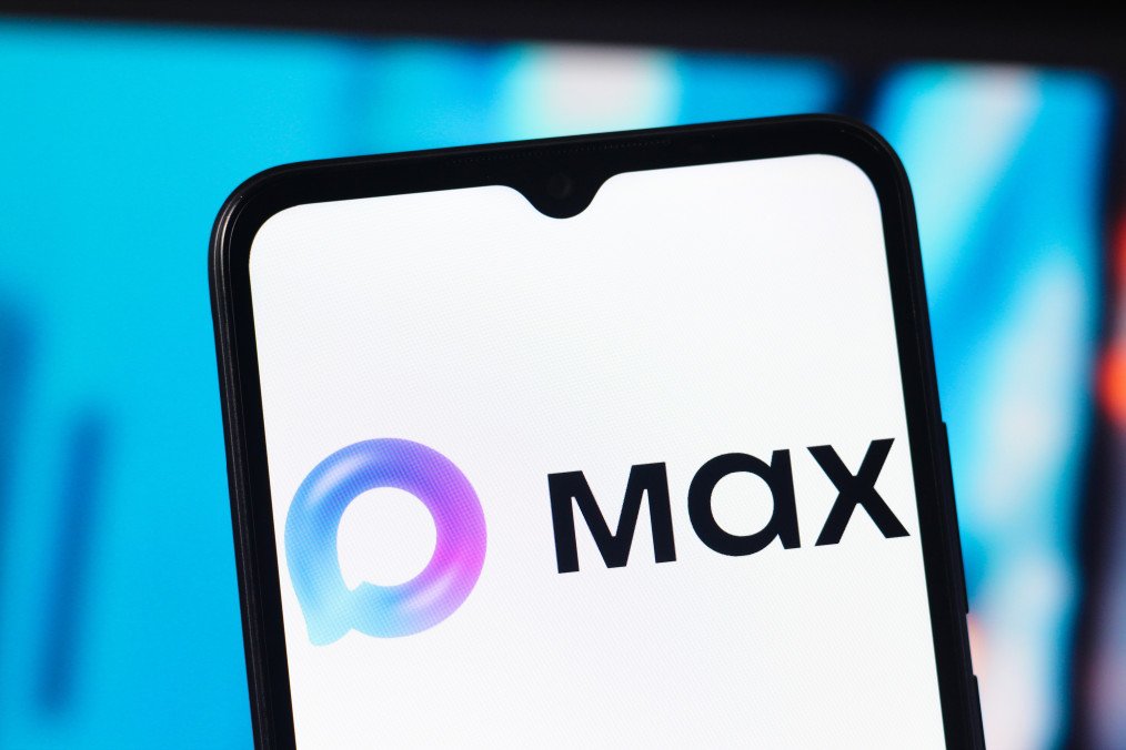 The Max Messenger logo is seen displayed on a smartphone screen.