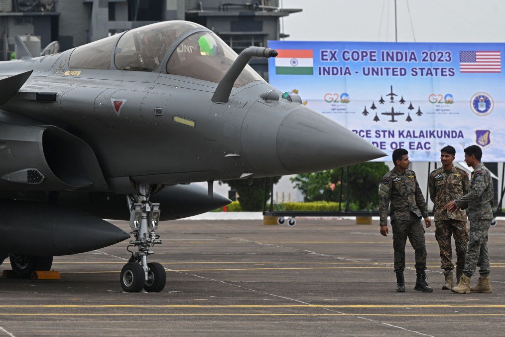 Indian Air Force (IAF) personnel stand next to a Rafale fighter jet on April 24, 2023.