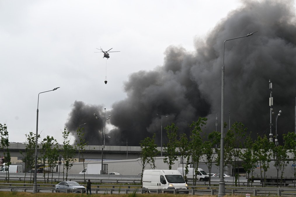 A firefighting helicopter is carrying water as black smoke billows from the area of Gazprom Neftâs Moscow oil refinery, located on the southeastern outskirts of Moscow, on June 18, 2026. (Source: Getty Images)