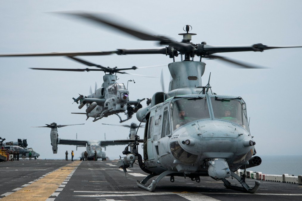A UH-1Y Venom utility helicopter (R) and an AH-1Z Viper attack helicopter land onboard the Wasp-class amphibious assault ship USS Kearsarge (LHD 3) on June 7, 2022, during the BALTOPS 22 Exercise in the Baltic Sea. (Source: Getty Images)