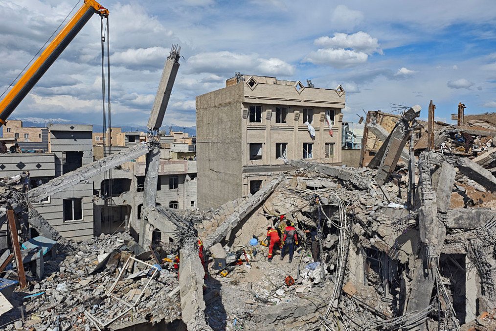 Rescue workers search for bodies in the rubble of a residential building following a hit in an airstrike in the early hours of March 27, 2026 in Tehran, Iran. (Source: Getty Images)
