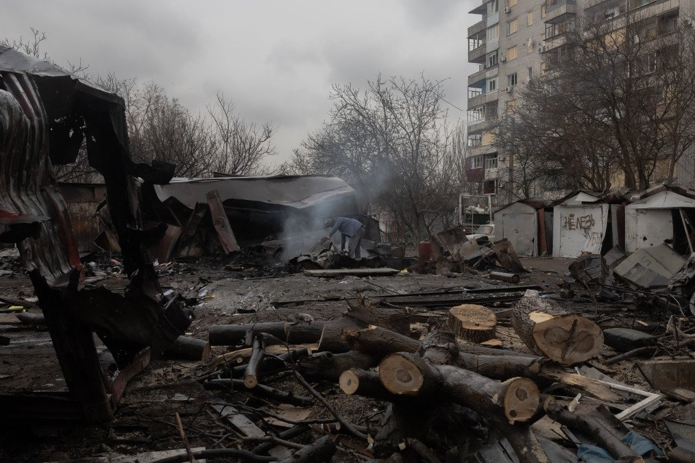 A man looks through debris at the site of a recent Russian air attack in front of a damaged residential apartment building in Zaporizhzhia on March 18, 2026. (Source: Getty Images)
