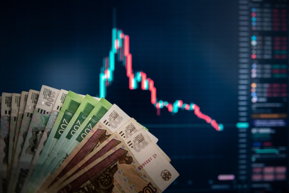 Russia Removes Key Economic Data From Public Access, Ukraine Intelligence Says Ruble bills in front of a screen showing a candlestick chart. Illustrative photo. (Source: Getty Images)