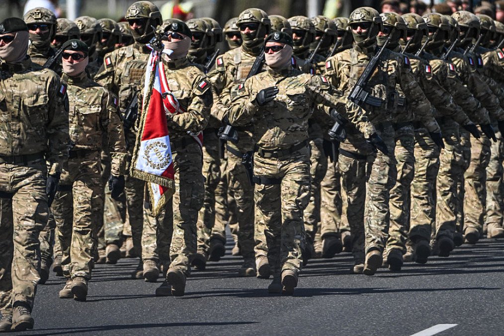 Special operations forces soldiers from the Polish Armed Forces march in camouflage tactical gear while carrying a unit standard during the annual Armed Forces Day military parade in Warsaw, Poland, on August 15, 2026. (Source: Getty Images) Special operations forces soldiers from the Polish Armed Forces march in camouflage tactical gear while carrying a unit standard during the annual Armed Forces Day military parade in Warsaw, Poland, on August 15, 2026. (Source: Getty Images)