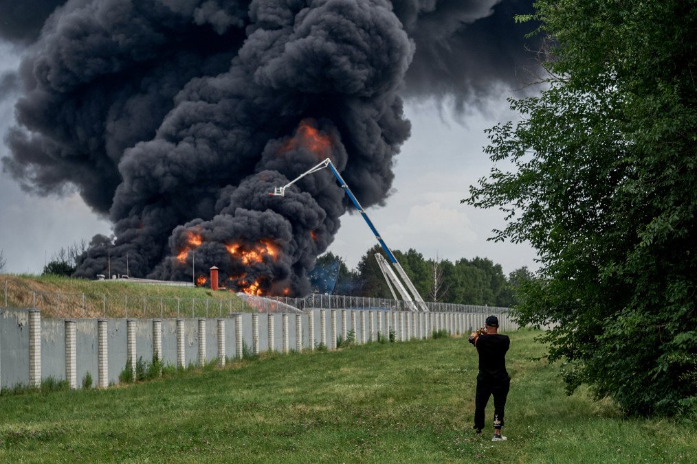A fire burns at an oil depot in Voronezh, Russia, as a local resident records the scene following reports of a fuel tank blaze in the city, June 24, 2023.(Photo: Getty Images)