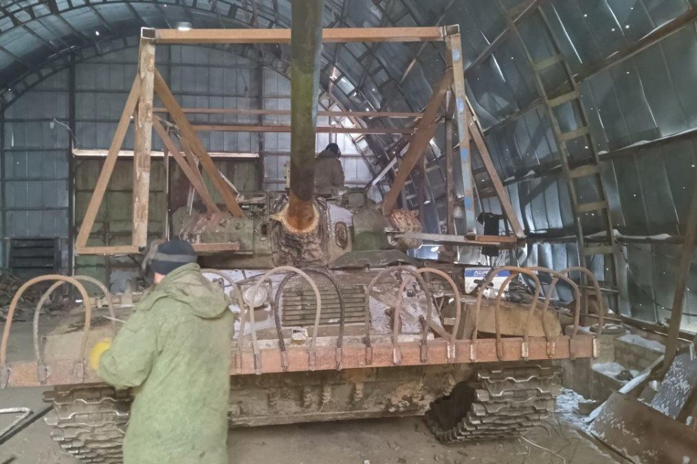 Russian soldiers installing a “cope cage” on a T-55AM medium tank, 218th Tank Regiment, 2026. (Source: These_Economics5014/Reddit)