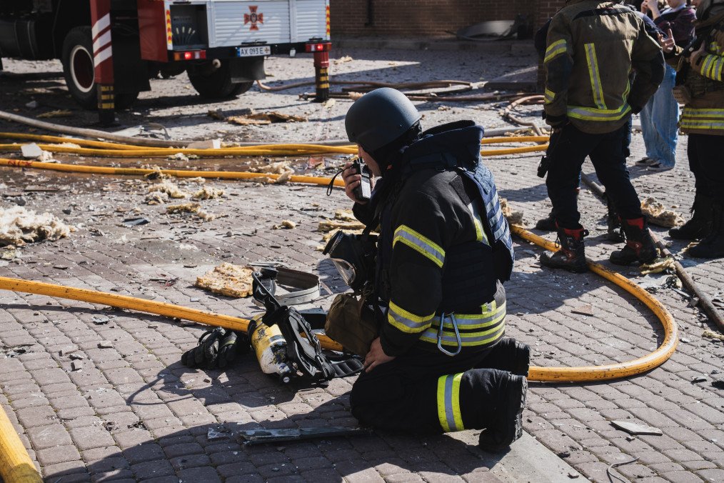 A firefighter uses a radio near debris and hoses at residential district after a Russian drone attack on April 2, 2026 in Kharkiv, Ukraine. (Source: Getty Images)