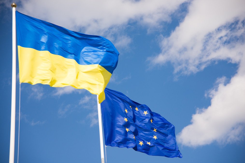 Flags of Ukraine and European Union (EU) with blue sky background. Illustrative photo. (Getty Images)