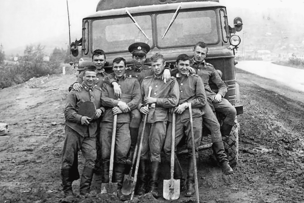 Soviet military construction battalion (“stroybat”) conscripts pose with shovels in front of a military truck during road construction in the Soviet Union. (Photo: open source)