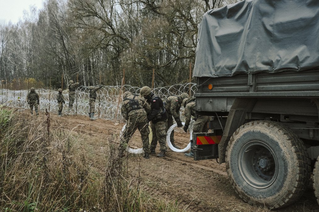Polish Army soldiers unload razor wire from a military truck while constructing a fence along the Polish border, with the Russian enclave of Kaliningrad, near Zerdziny, Poland, on November 5, 2022. (Source: Getty Images)