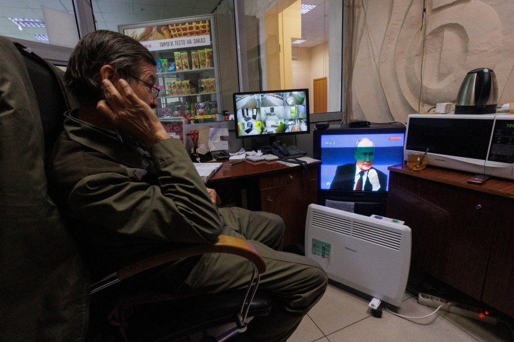 A security guard watches a live broadcast of Russian President Vladimir Putin’s year-end press conference on a TV screen at his workplace in an administrative building in Yekaterinburg on December 14, 2023. (Source: Getty Images)