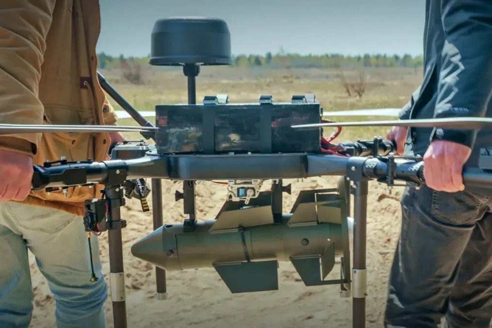 Two handlers carry a large heavy-lift bomber drone with the newly developed “Firefly” precision-guided munition mounted to its underbelly. (Source: Ministry of Defense of Ukraine) Two handlers carry a large heavy-lift bomber drone with the newly developed “Firefly” precision-guided munition mounted to its underbelly. (Source: Ministry of Defense of Ukraine)