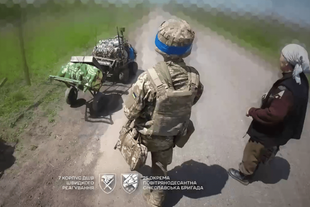 Ukrainian paratroopers help an elderly civilian flee the frontline village.
