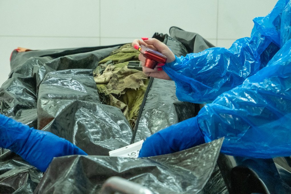 Experts begin to take photographs of various indicators that could potentially lead to the identification of a fallen Ukrainian serviceman. (Photo: Daniel Kosoy / UNITED24 Media) 