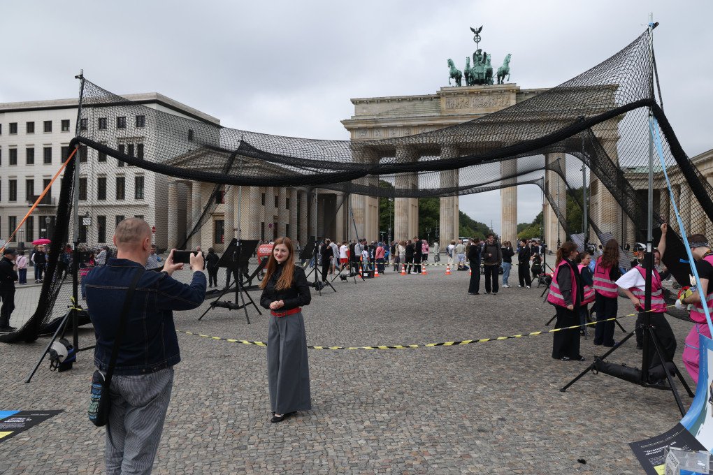 A couple photograph each other at an installation of an anti-drone netting tunnel in front of the Brandenburg Gate on Ukraine independence day on August 24, 2026 in Berlin, Germany. (Source: Getty Images) A couple photograph each other at an installation of an anti-drone netting tunnel in front of the Brandenburg Gate on Ukraine independence day on August 24, 2026 in Berlin, Germany.