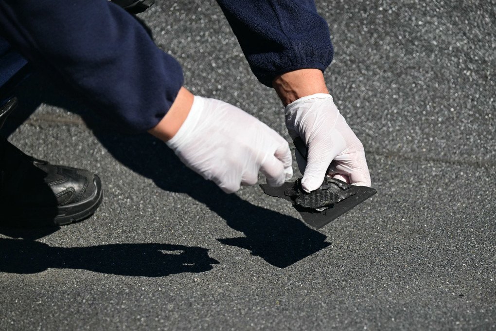 An investigator holds a piece of debris believed to be from a Russian drone that struck an apartment building in Galati, eastern Romania. (Photo by Daniel Mihailescu via Getty Images)
