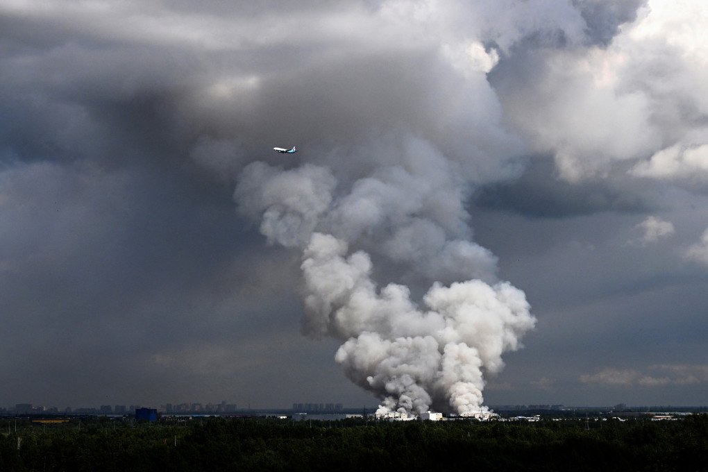 A passenger plane flies past smoke rising from a warehouse for a Russian e-commerce giant near Saint Petersburg after being hit by Ukrainian drones early on July 24, 2026. (Photo by AFP via Getty Images) A passenger plane flies past smoke rising from a warehouse for a Russian e-commerce giant near Saint Petersburg after being hit by Ukrainian drones early on July 24, 2026. (Photo by AFP via Getty Images)