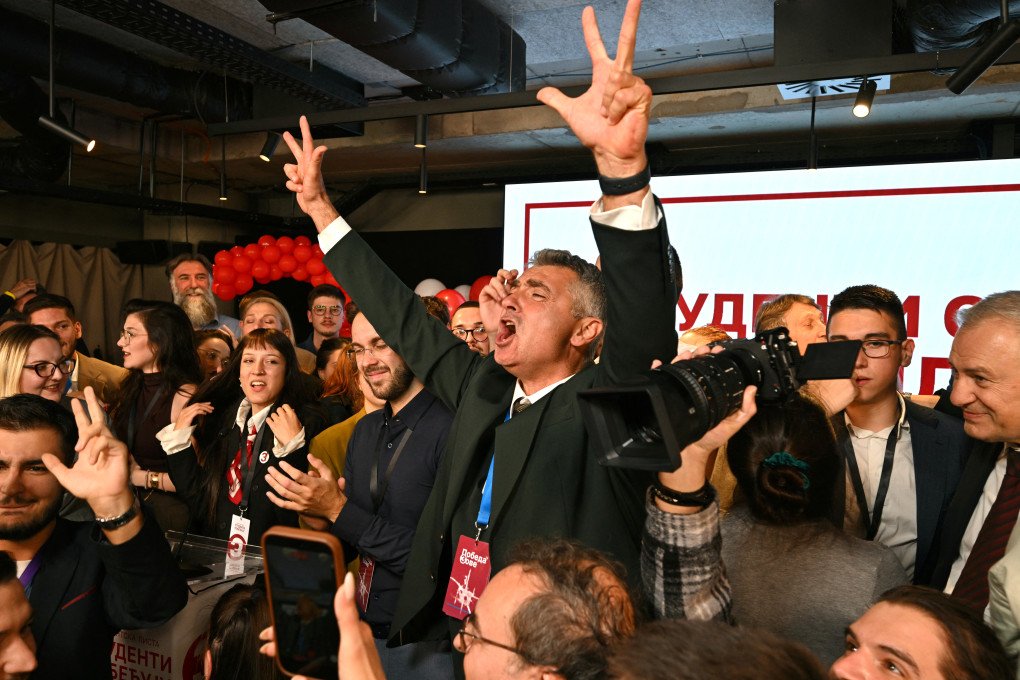 Ilija Srdanovic (C), main candidate on the student-backed electoral list, celebrates the news that Serbia's ruling party have conceded defeat in the Serbian parliamentary elections, at the Students' List headquarters in Belgrade on October 25, 2026. (Photo by Andrej Isakovic via Getty Images)