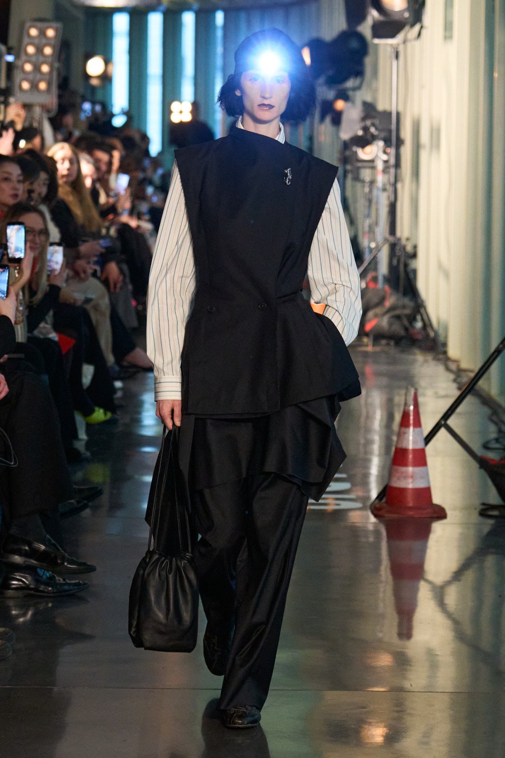 A model confidently showcases an elegant black and white layered look, with a structured blazer and voluminous pants. (Source: LITKOVSKA press office)