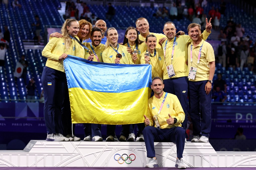 Gold medallists Olena Kravatska, Alina Komashchuk, Olga Kharla and Yuliia Bakastova of Team Ukraine and their coaches pose on the podium during the Fencing Women's Sabre Team medal ceremony on day eight of the Olympic Games Paris 2024 at Grand Palais on August 3, 2024 in Paris, France. (Source: Getty Images)
