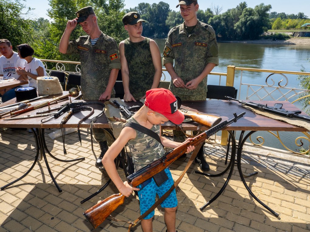 Un niño posa con un arma el Día de la República, septiembre de 2023, Transnistria (Fuente: Peter Dench a través de Getty Images)