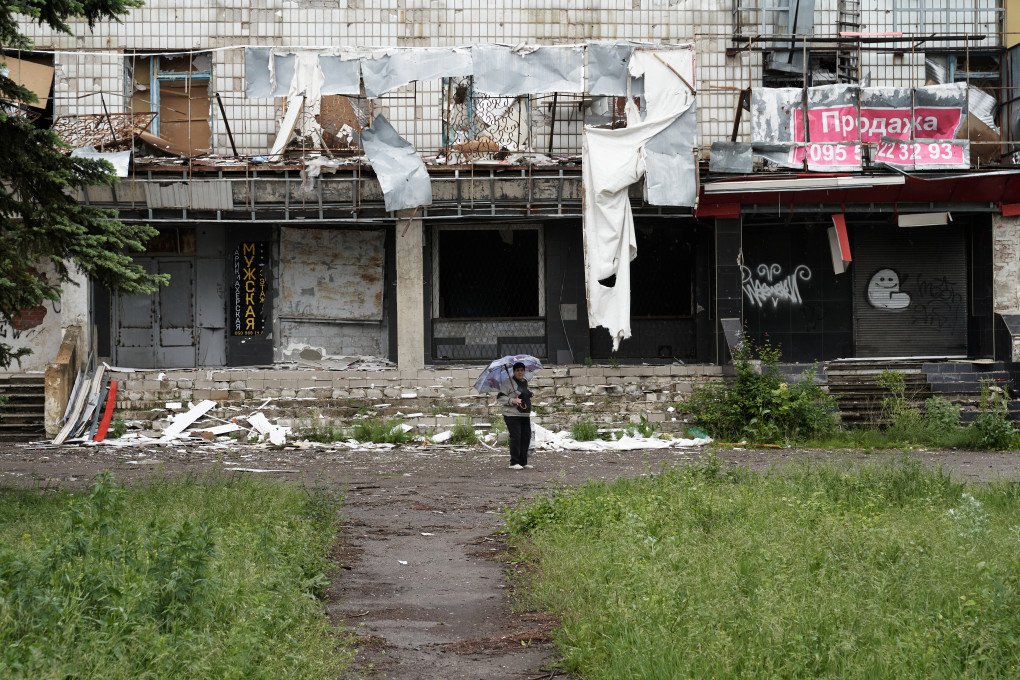 Woman standing in front of a destroyed grocery store. Woman standing in front of a destroyed grocery store.