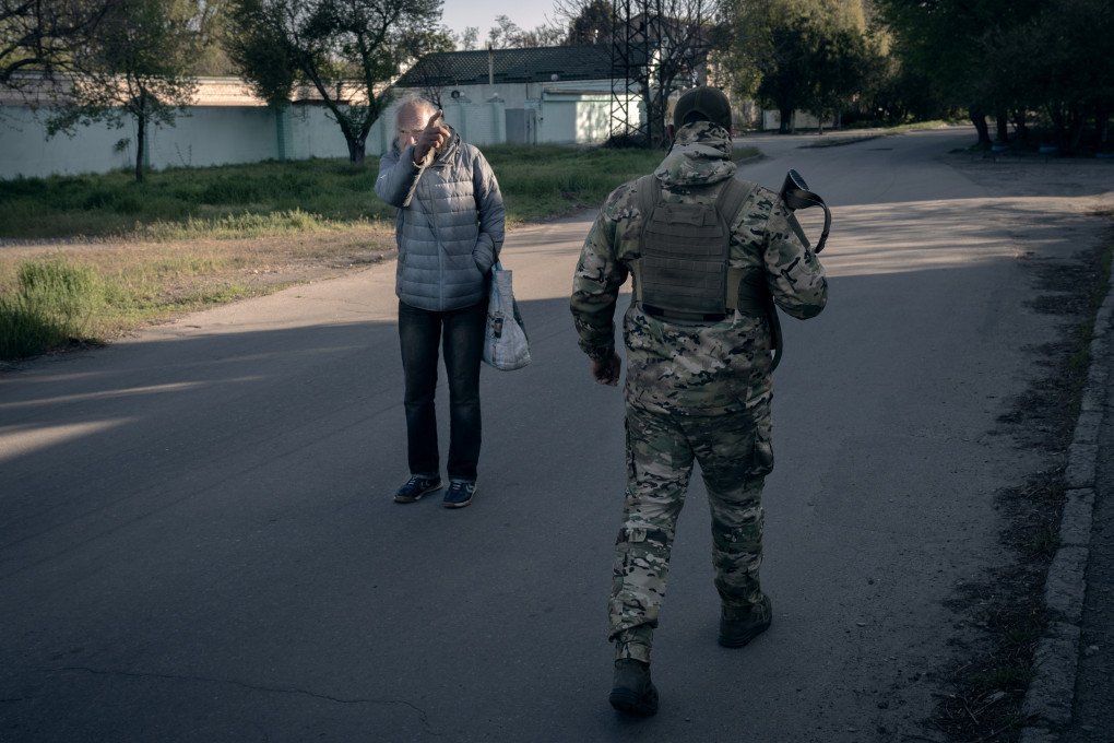 An elderly man in the Dniprovskyi neighborhood points in the direction where he spotted a Russian FPV drone. Kherson, Ukraine, May 2026. Photo: Joshua Olley / UNITED24 Media.