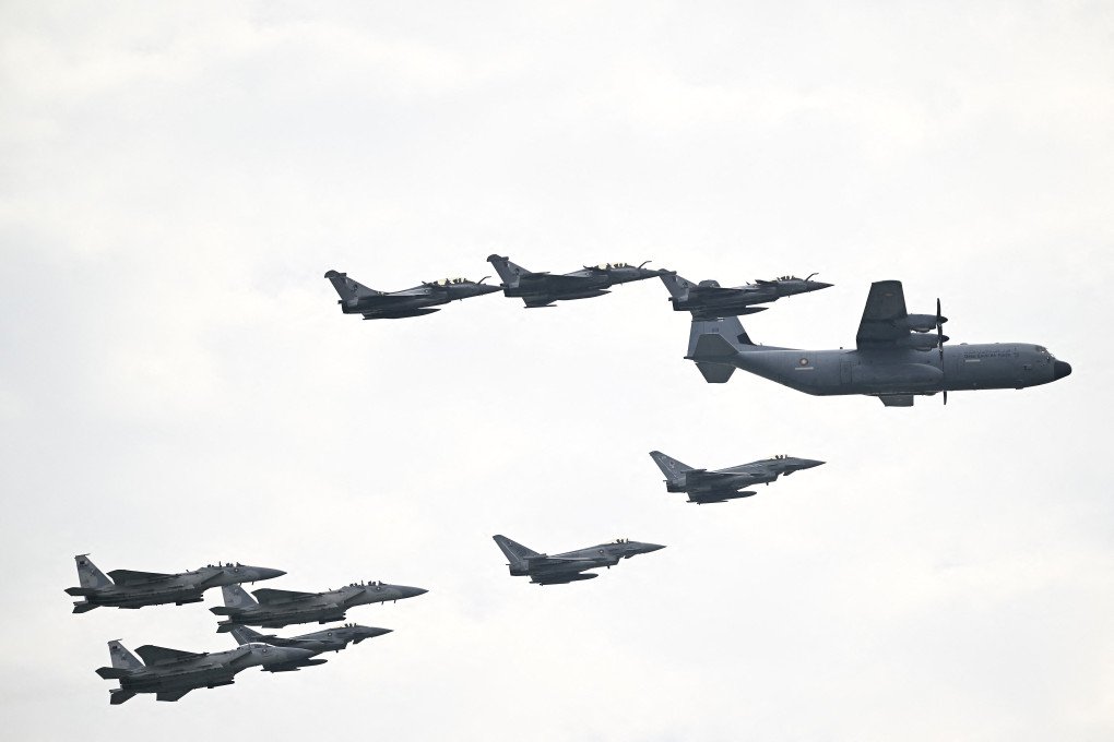A Qatar Emiri Air Force C-130J, Dassault Rafale, F-15E, and Eurofighter Typhoon fighter jets take part in a flypast during celebrations marking Qatar National Day, in Doha on December 18, 2025. (Source: Getty Images)