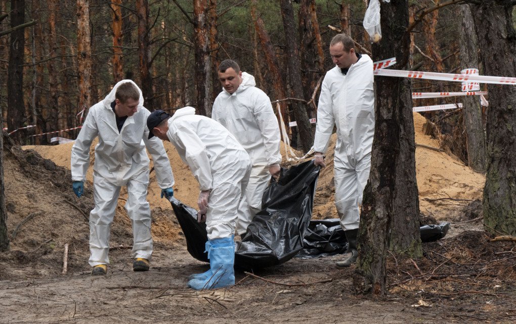 Workers carry bodies to a truck as a part of an investigation of war crimes in Izium, Ukraine. Over 400 bodies were recovered from mass graves in Izium after liberation from a six month Russian occupation. Photo: Stephen J. Boitano/LightRocket via Getty Images