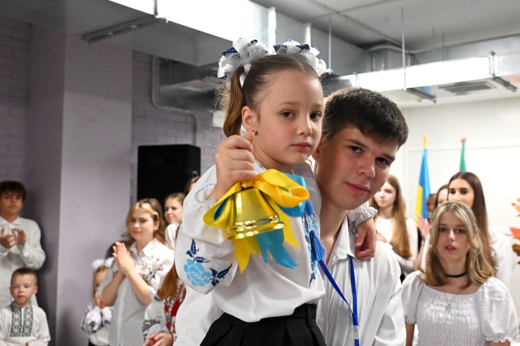A first-grader rings a bell during a ceremony marking the first day of the new school year at an underground school in Kharkiv on September 1, 2025. Photo: SERGEY BOBOK/AFP via Getty Images