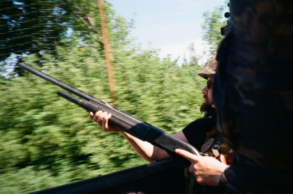 A soldier with a shotgun rides in the back of a pickup truck, constantly scanning the skies for drones. (Photo: Conall Kearney) A soldier with a shotgun rides in the back of a pickup truck, constantly scanning the skies for drones. (Photo: Conall Kearney)